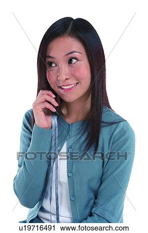 Young woman smiling, looking away, holding mobile phone View Large Photo Image Stock Image - Young woman smiling, looking away, holding mobile phone. Fotosearch