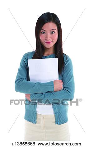 Young woman standing, holding documents, front view View Large Photo Image Stock Photo - Young woman standing, holding documents, front view. Fotosearch