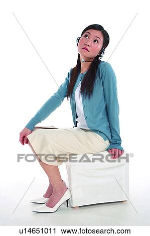 Young woman wearing headphone, looking up and thinking, full length View Large Photo Image Stock Image - Young woman wearing headphone, looking up and thinking, full length. Fotosearch