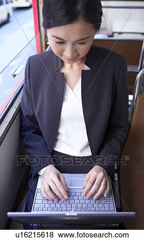 Businesswoman riding tram using laptop View Large Photo Image Stock Photo - Businesswoman riding tram using laptop. Fotosearch