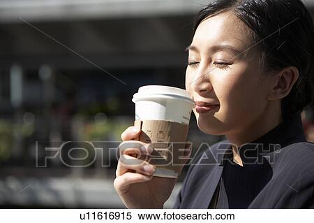 Stock Photography - Young Businesswoman Holding Coffee Cup, Eyes Closed. Fotosearch