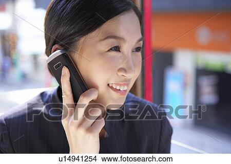 Young Businesswoman Riding Tram and using mobile phone, Smiling View Large Photo Image Picture - Young Businesswoman Riding Tram and using mobile phone, Smiling. Fotosearch