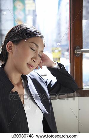 Stock Photo - Young Businesswoman Riding Tram, Eyes Closed. Fotosearch