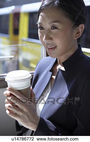 Young Businesswoman Riding Tram, Holding Coffee Cup, Looking Away, Smiling View Large Photo Image Stock Image - Young Businesswoman Riding Tram, Holding Coffee Cup, Looking Away, Smiling. Fotosearch