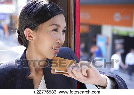 Young Businesswoman Riding Tram, Holding a Diary, Looking Away View Large Photo Image Stock Image - Young Businesswoman Riding Tram, Holding a Diary, Looking Away. Fotosearch