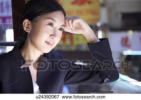 Stock Photo - Young Businesswoman Riding Tram, Looking Away, Smiling. Fotosearch