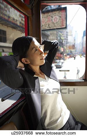 Stock Photo - Young Businesswoman Riding Tram, Looking Away. Fotosearch