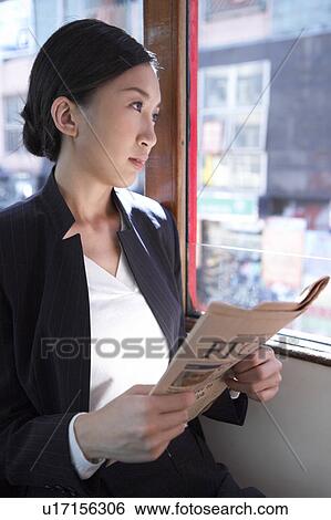 Young Businesswoman Riding Tram, Holding Newspaper, Looking Away View Large Photo Image Stock Photograph - Young Businesswoman Riding Tram, Holding Newspaper, Looking Away. Fotosearch