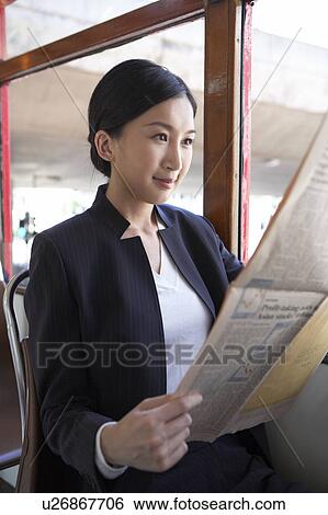 Young Businesswoman Riding Tram, Reading Newspaper View Large Photo Image Stock Photograph - Young Businesswoman Riding Tram, Reading Newspaper. Fotosearch