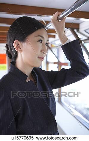 Young Businesswoman Riding Tram, Standing, Holding Pole View Large Photo Image Stock Photography - Young Businesswoman Riding Tram, Standing, Holding Pole. Fotosearch