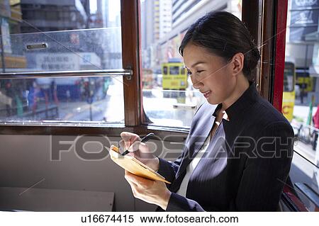 Young Businesswoman Riding Tram, Taking Notes in a Diary View Large Photo Image Stock Photography - Young Businesswoman Riding Tram, Taking Notes in a Diary. Fotosearch