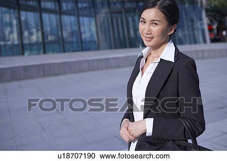 Young Businesswoman Standing in Street, Carrying Briefcase, Smiling View Large Photo Image Stock Image - Young Businesswoman Standing in Street, Carrying Briefcase, Smiling. Fotosearch