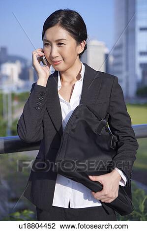 Young Businesswoman Standing in Street, Using Mobile Phone, Smiling View Large Photo Image Stock Image - Young Businesswoman Standing in Street, Using Mobile Phone, Smiling. Fotosearch