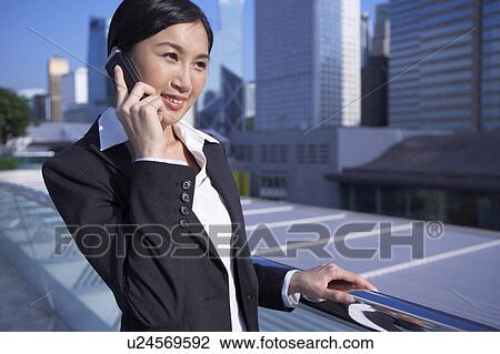 Young Businesswoman Standing in Street, Using Mobile Phone, Smiling View Large Photo Image Stock Image - Young Businesswoman Standing in Street, Using Mobile Phone, Smiling. Fotosearch
