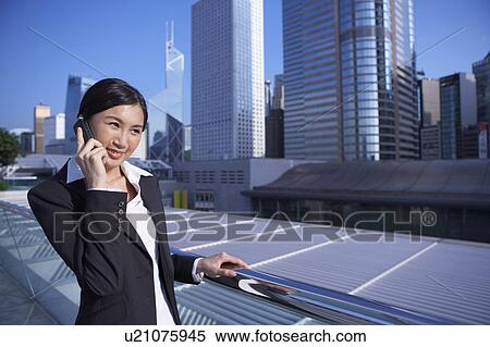 Young Businesswoman Standing in Street, Using Mobile Phone, Smiling View Large Photo Image Stock Photography - Young Businesswoman Standing in Street, Using Mobile Phone, Smiling. Fotosearch