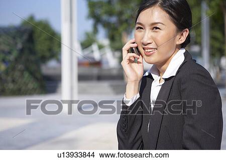 Young Businesswoman Using Mobile Phone in Street, Smiling View Large Photo Image Picture - Young Businesswoman Using Mobile Phone in Street, Smiling. Fotosearch