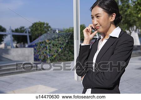 Stock Image - Young Businesswoman using mobile phone, Smiling. Fotosearch