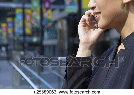 Stock Image - Young Businesswoman using mobile phone, Smiling. Fotosearch