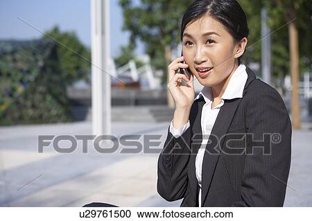 Stock Image - Young Businesswoman using mobile phone, Smiling. Fotosearch