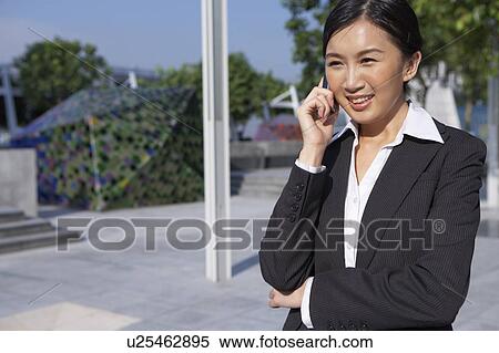 Young Businesswoman using mobile phone, Smiling View Large Photo Image Stock Photography - Young Businesswoman using mobile phone, Smiling. Fotosearch