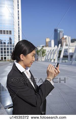 Young Businesswoman using Personal Digital Assistant, Side View View Large Photo Image Stock Image - Young Businesswoman using Personal Digital Assistant, Side View. Fotosearch