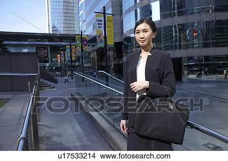 Picture - Young Busineswoman Standing in Street, Looking Away. Fotosearch