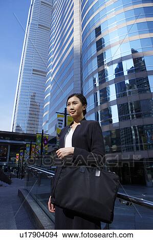Young Busineswoman Standing in Street, Looking Away View Large Photo Image Picture - Young Busineswoman Standing in Street, Looking Away. Fotosearch