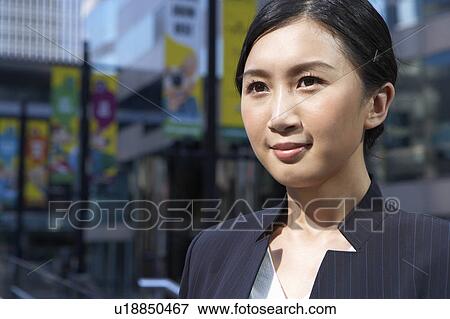 Stock Photo - Young Busineswoman Standing in Street, Looking Away. Fotosearch