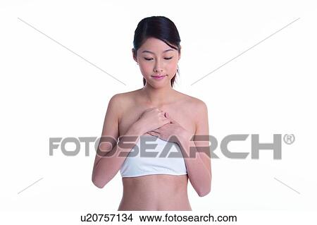 Picture - Young girl standing with eye closed and hands in front of chest. Fotosearch