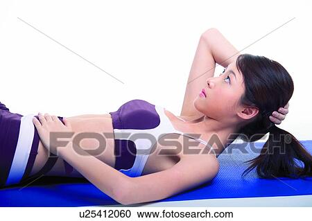 Stock Image - Young woman doing sit-ups. Fotosearch
