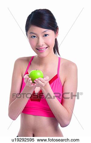 Stock Photography - Young woman holding green apple. Fotosearch