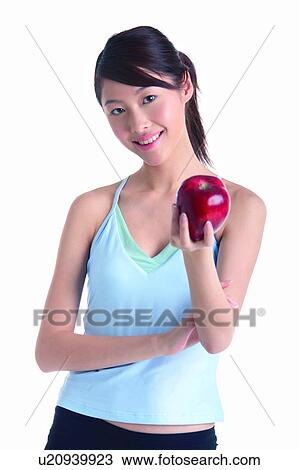 Young woman holding red apple, front view View Large Photo Image Stock Image - Young woman holding red apple, front view. Fotosearch