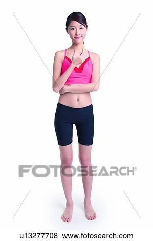 Stock Photo - Young woman in sporty wear, standing and holding something. Fotosearch