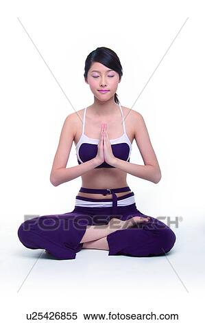 Stock Photography - Young woman in sukhasana pose, hands in prayer position. Fotosearch