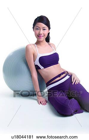 Young woman leaning on a big ball View Large Photo Image Stock Image - Young woman leaning on a big ball. Fotosearch