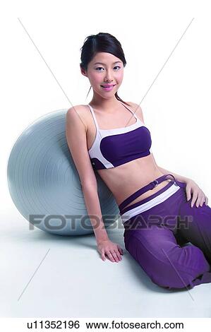Stock Photograph - Young woman leaning on a big ball. Fotosearch