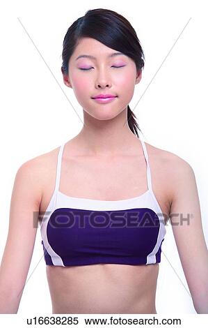 Stock Photography - Young woman sitting, eyes closed, close-up. Fotosearch