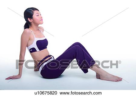 Stock Image - Young woman sitting on floor, enjoying. Fotosearch
