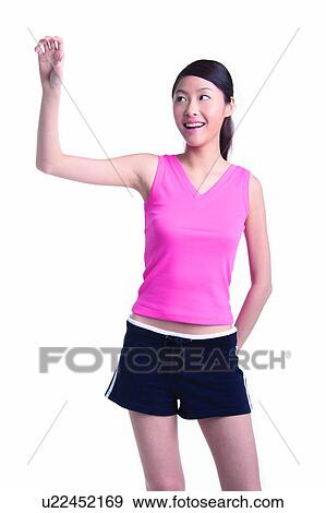 Stock Photo - Young woman standing and holding something. Fotosearch