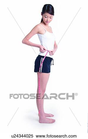 Young woman standing and measuring, full length, side view View Large Photo Image Stock Photography - Young woman standing and measuring, full length, side view. Fotosearch