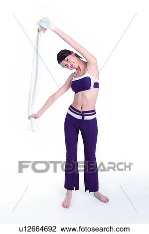 Stock Image - Young woman standing and pulling towel. Fotosearch
