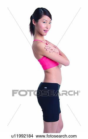 Young woman standing with arms crossed View Large Photo Image Picture - Young woman standing with arms crossed. Fotosearch