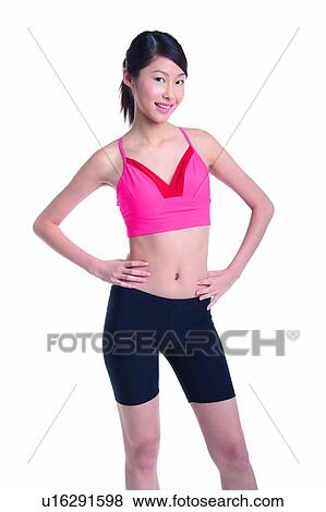 Stock Photo - Young woman standing with hands on waist. Fotosearch