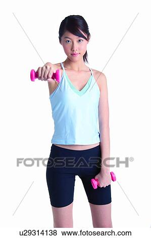 Young woman wearing tank top and lifting dumbbell, front view View Large Photo Image Stock Photo - Young woman wearing tank top and lifting dumbbell, front view. Fotosearch