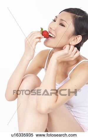 Stock Photography - Portrait of Natural Young girl eating Strawberry. Fotosearch