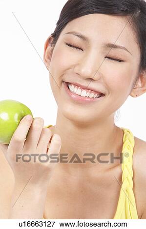 Portrait of Natural Young girl holding Apple, Smiling View Large Photo Image Stock Photo - Portrait of Natural Young girl holding Apple, Smiling. Fotosearch