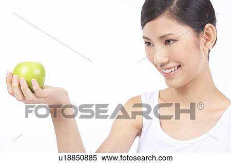 Stock Photography - Portrait of Natural Young girl holding apple in hand. Fotosearch