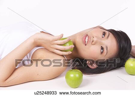 Portrait of Natural Young girl lying on Floor, Holding Apple View Large Photo Image Stock Image - Portrait of Natural Young girl lying on Floor, Holding Apple. Fotosearch
