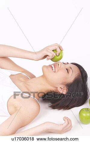 Portrait of Natural Young girl lying on Floor, Holding Apple View Large Photo Image Stock Photo - Portrait of Natural Young girl lying on Floor, Holding Apple. Fotosearch