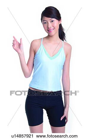 Stock Image - Young woman standing and holding something. Fotosearch